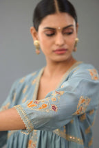Light blue silk chanderi kurta-dress set with all-over zari, dori and contrast silk thread embroidery, highlighted with gold sequins work.