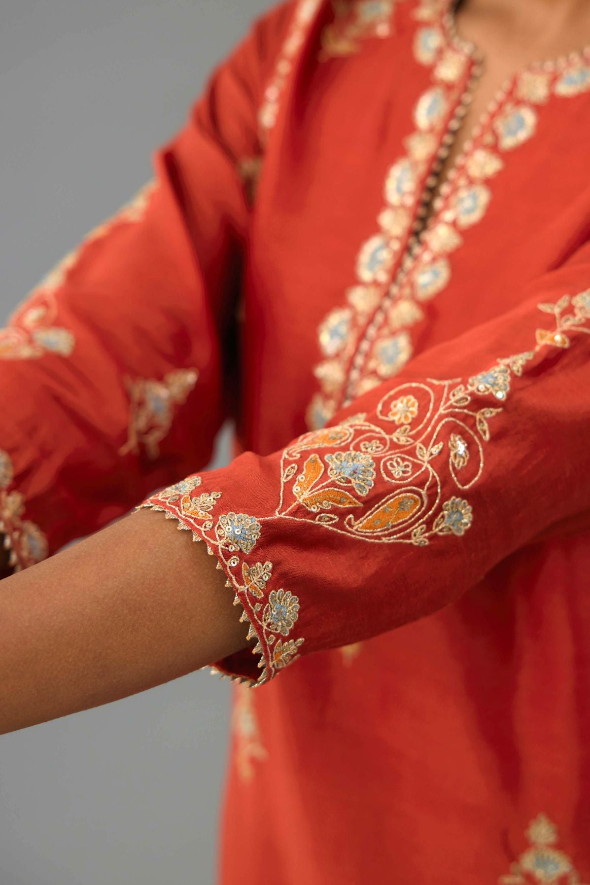 Rust silk chanderi straight kurta set with all-over zari, dori and contrast silk thread embroidery, highlighted with gold sequins work.