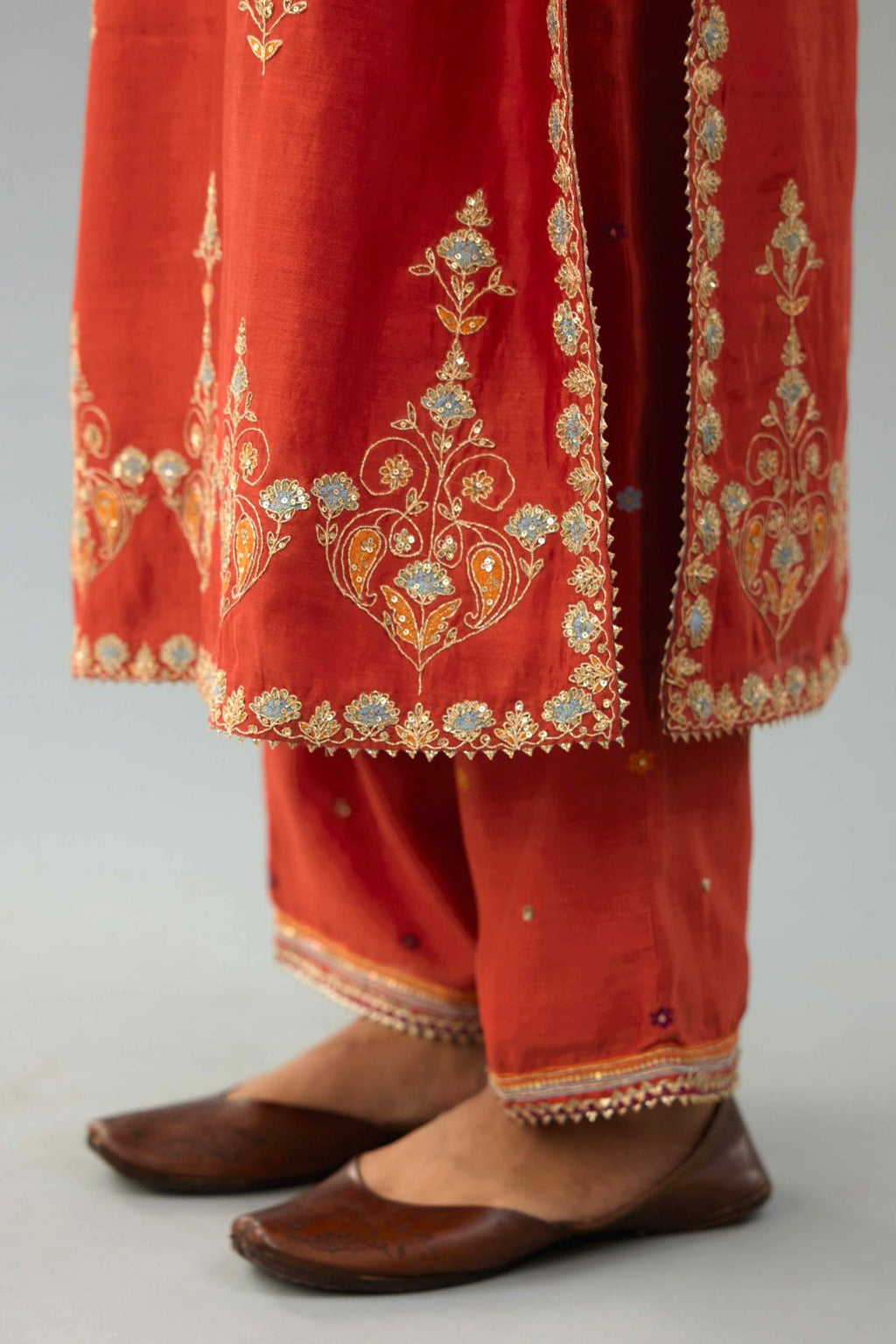Rust silk chanderi straight kurta set with all-over zari, dori and contrast silk thread embroidery, highlighted with gold sequins work.