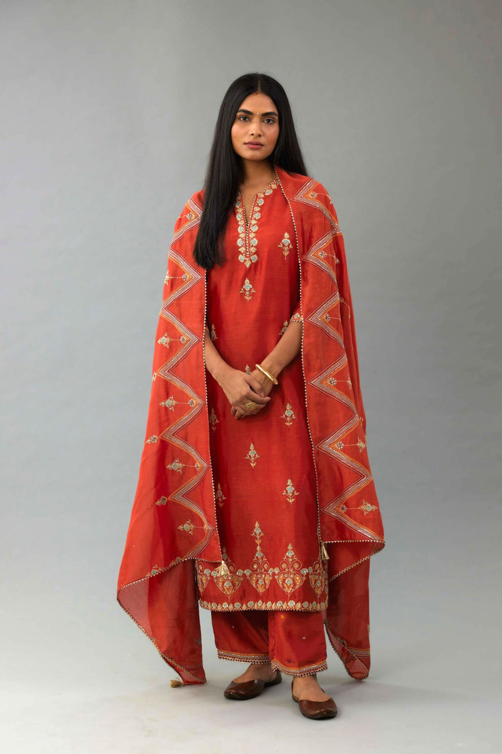 Rust silk chanderi straight kurta set with all-over zari, dori and contrast silk thread embroidery, highlighted with gold sequins work.