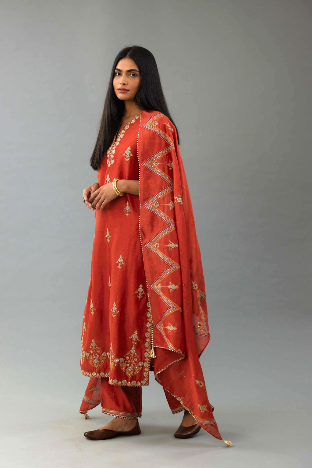 Rust silk chanderi straight kurta set with all-over zari, dori and contrast silk thread embroidery, highlighted with gold sequins work.