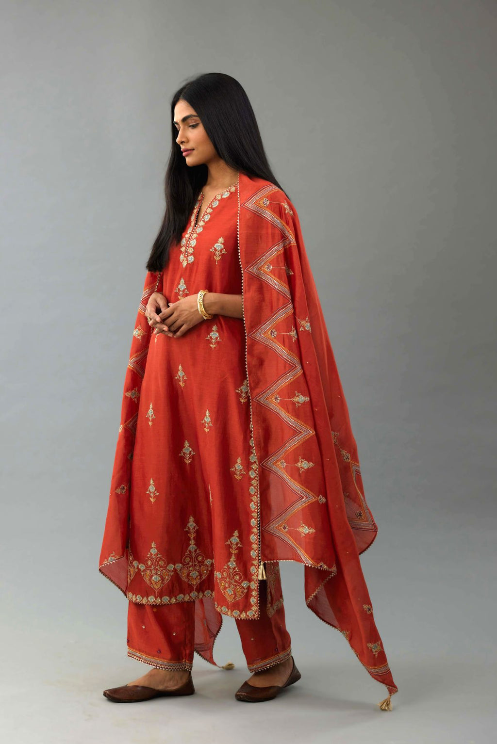 Rust silk chanderi straight kurta set with all-over zari, dori and contrast silk thread embroidery, highlighted with gold sequins work.