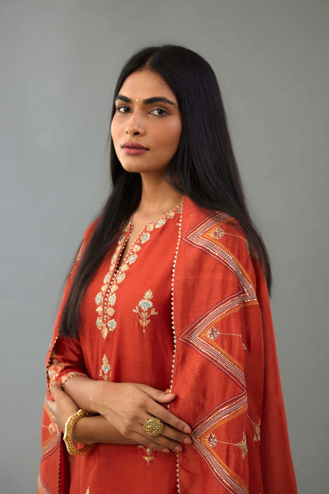 Rust silk chanderi straight kurta set with all-over zari, dori and contrast silk thread embroidery, highlighted with gold sequins work.