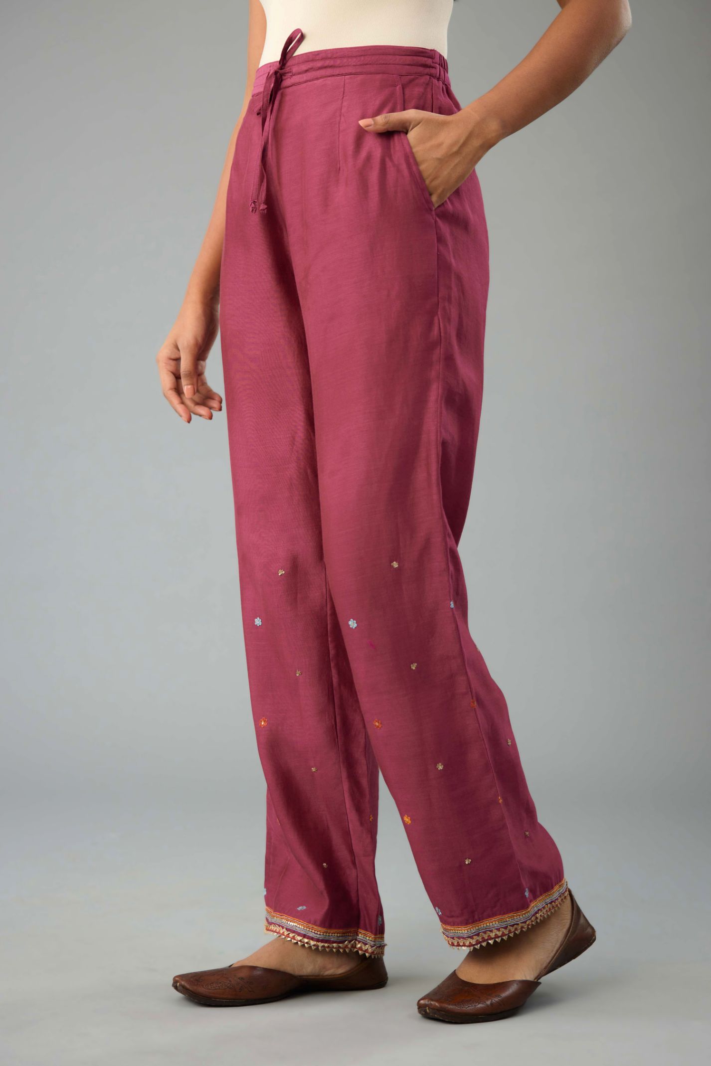 Wine silk chanderi straight pants with dori and contrast silk thread embroidery,  detailed with gold sequins work.