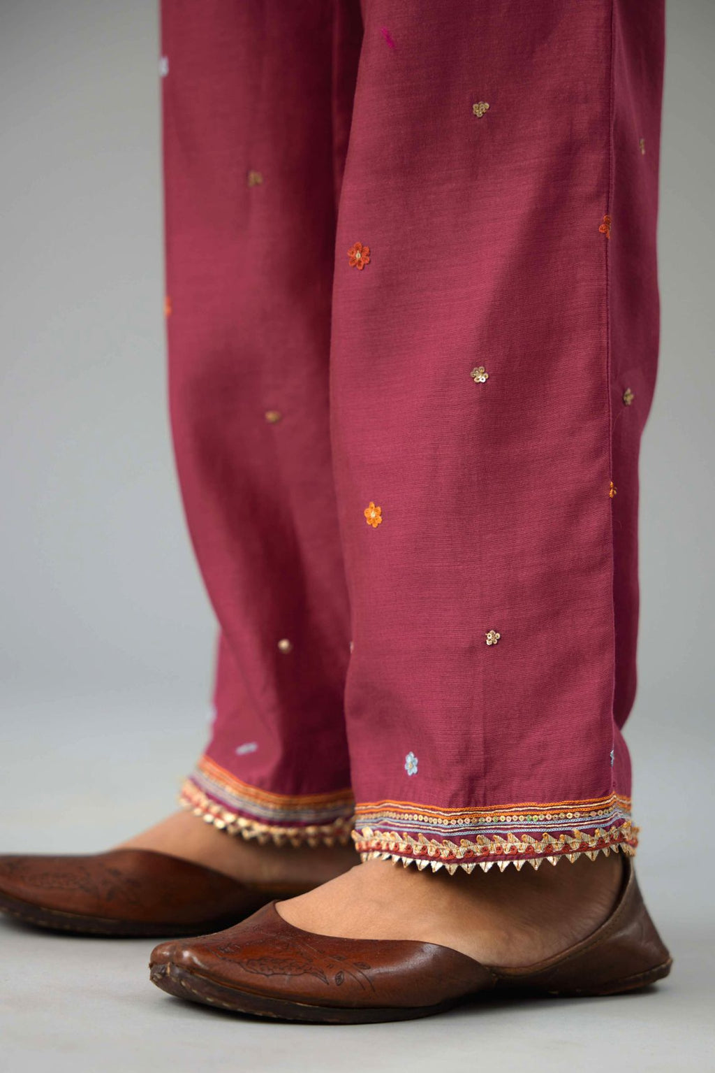Wine silk chanderi straight pants with dori and contrast silk thread embroidery,  detailed with gold sequins work.