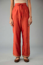 Rust silk chanderi straight pants with dori and contrast silk thread embroidery,  detailed with gold sequins work.