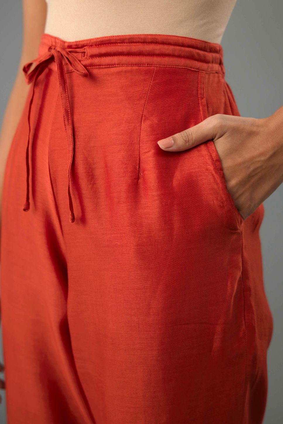 Rust silk chanderi straight pants with dori and contrast silk thread embroidery,  detailed with gold sequins work.