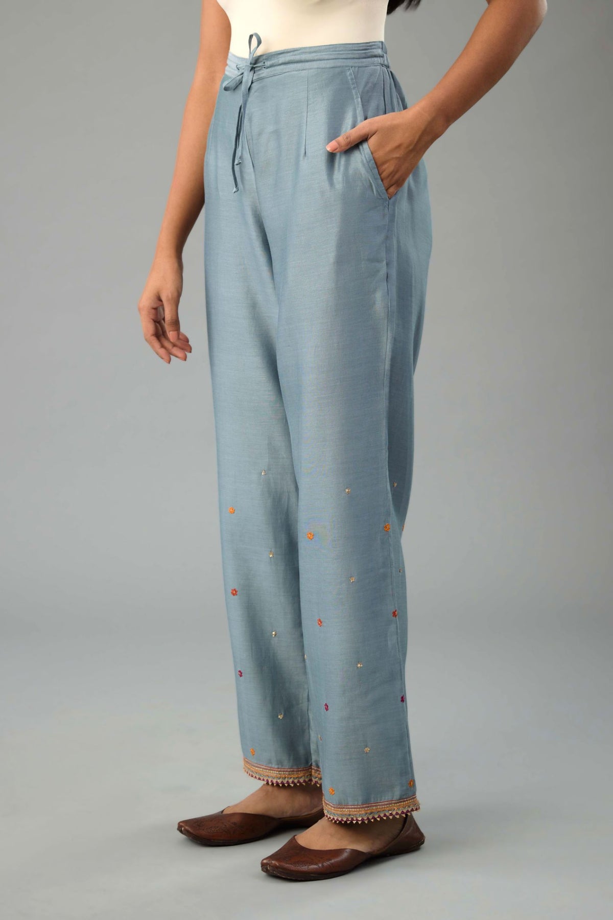 Light blue silk chanderi straight pants with dori and contrast silk thread embroidery,  detailed with gold sequins work.