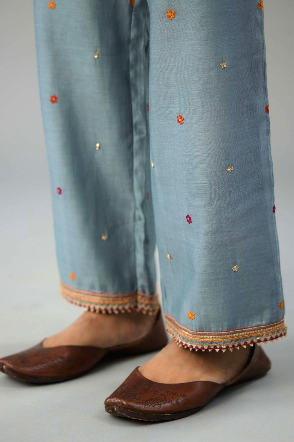 Light blue silk chanderi straight pants with dori and contrast silk thread embroidery,  detailed with gold sequins work.