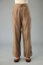 Taupe silk chanderi straight pants with dori and contrast silk thread embroidery,  detailed with gold sequins work.