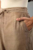 Taupe silk chanderi straight pants with dori and contrast silk thread embroidery,  detailed with gold sequins work.