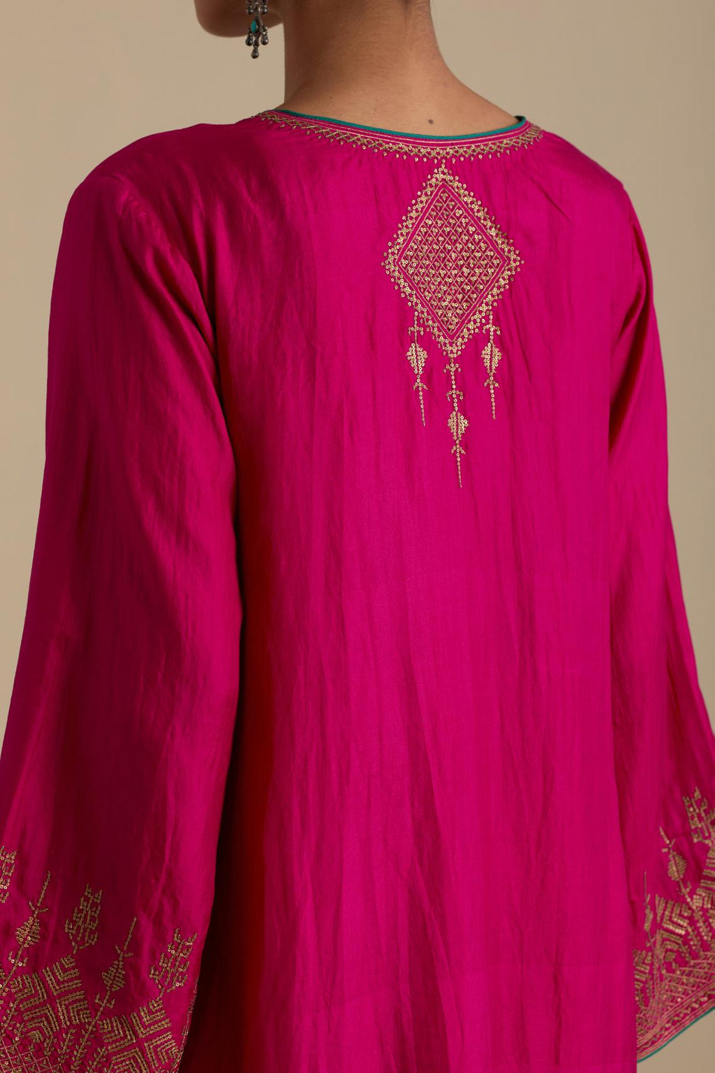 Fuchsia knee length A-line kurta set, highlighted with dull gold zari and sequins handwork.