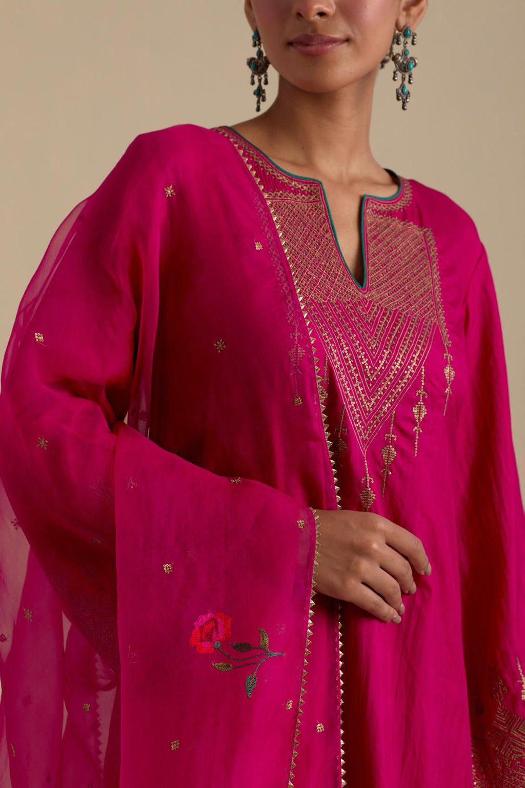 Fuchsia silk organza dupatta, highlighted with delicate dull gold sequins work and all-over thread embroidery roses, with a large bunch at the dupatta corners.