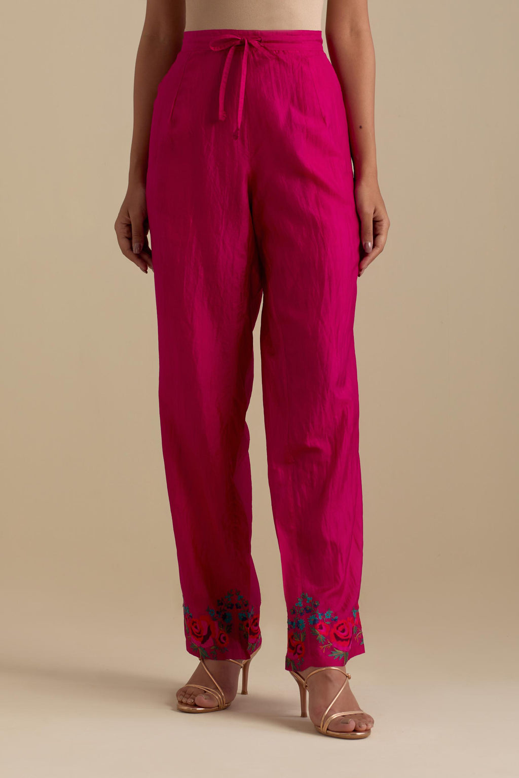 Fuchsia silk straight pants with roses in thread embroidery at the hem.