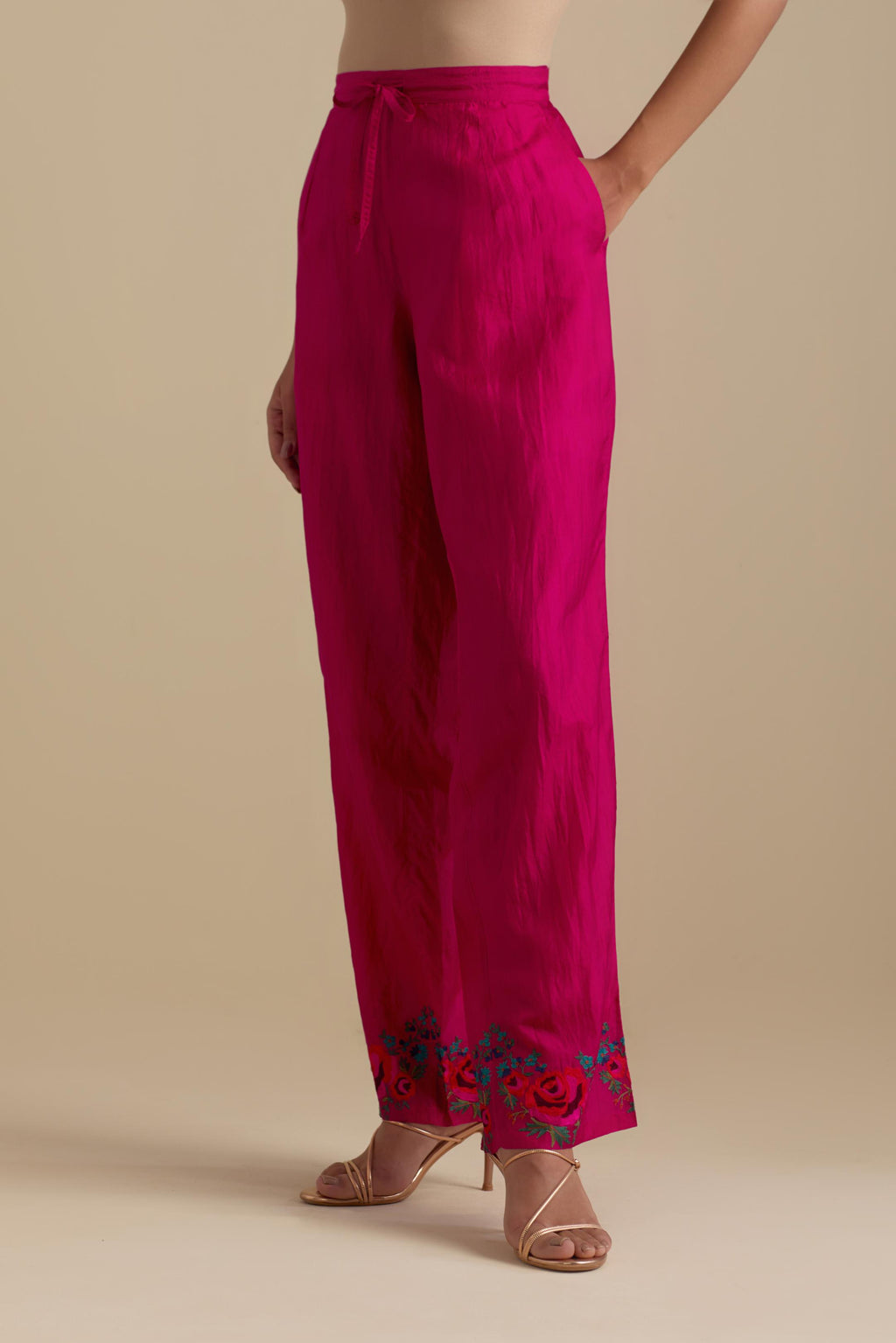 Fuchsia silk straight pants with roses in thread embroidery at the hem.