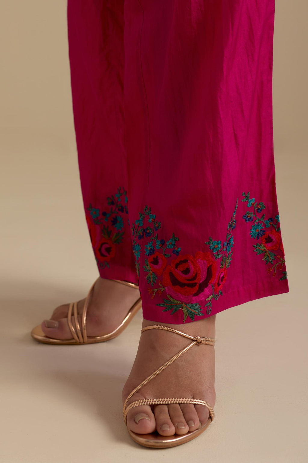 Fuchsia silk straight pants with roses in thread embroidery at the hem.