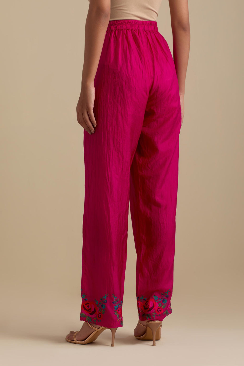 Fuchsia silk straight pants with roses in thread embroidery at the hem.