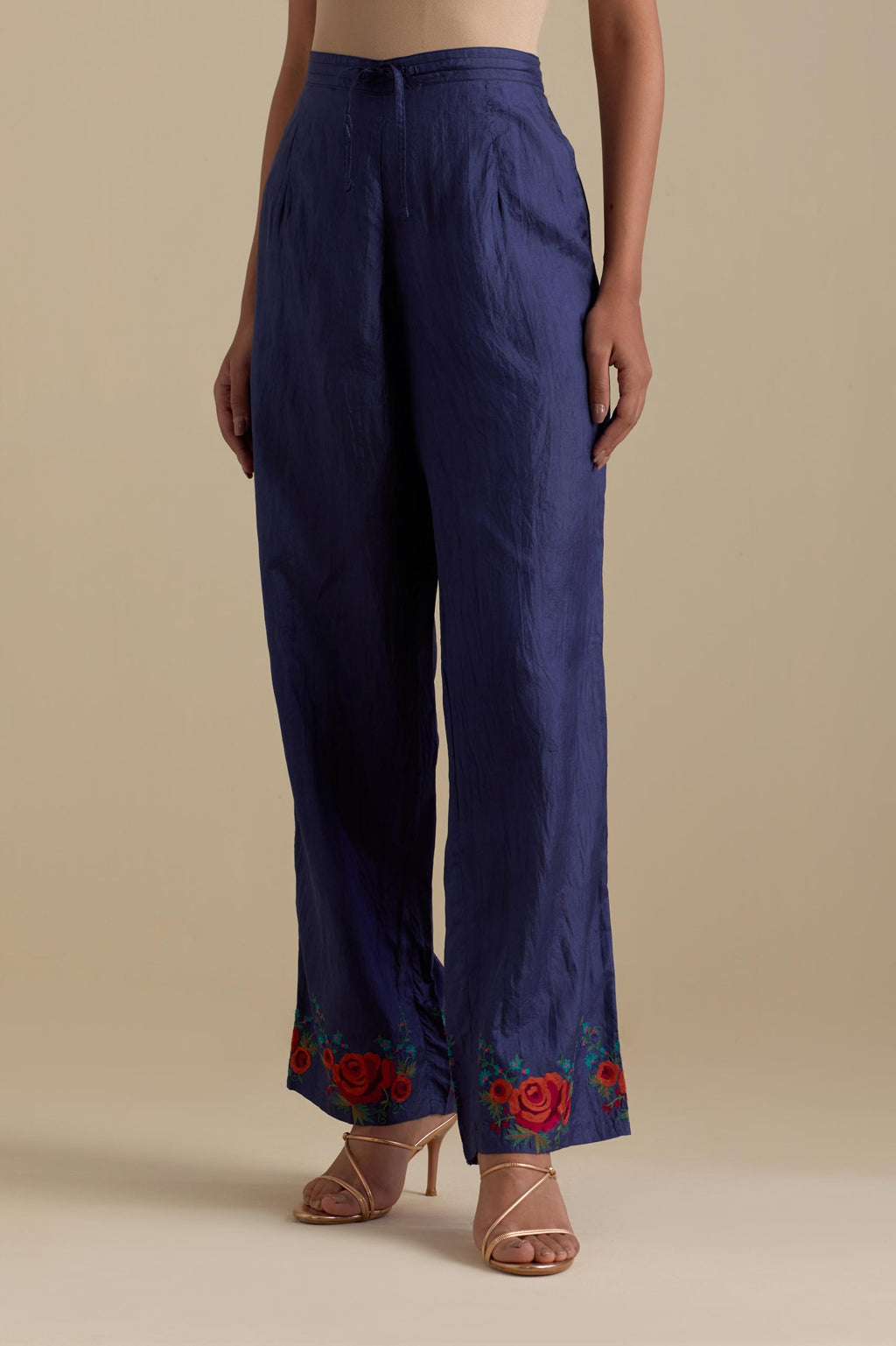 Blue silk straight pants with roses in thread embroidery at the hem.