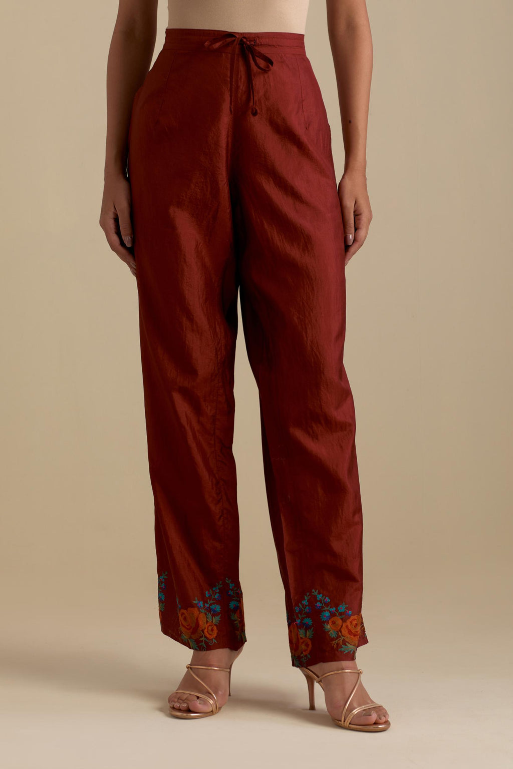 Maroon silk straight pants with roses in thread embroidery at the hem.