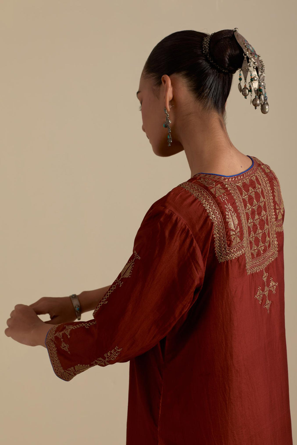 Maroon silk straight kurta set, highlighted with dull gold zari and sequins handwork.