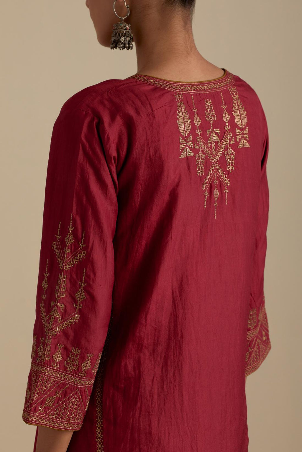 Barn red silk straight long kurta set with side panels, highlighted with dull gold zari and sequins handwork.