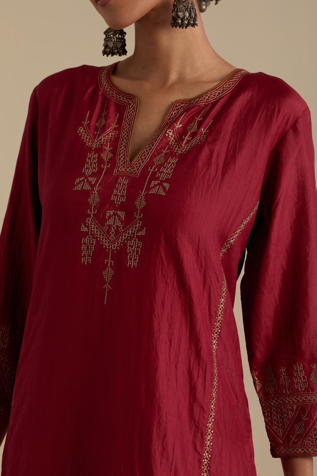 Barn red silk straight long kurta set with side panels, highlighted with dull gold zari and sequins handwork.