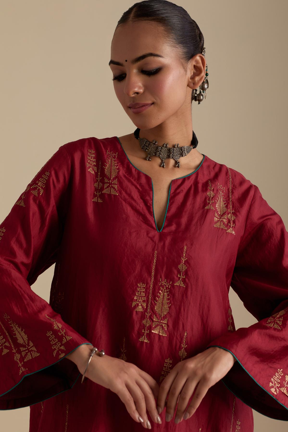 Barn red silk A-line short kurta set, highlighted with dull gold zari and sequins handwork.