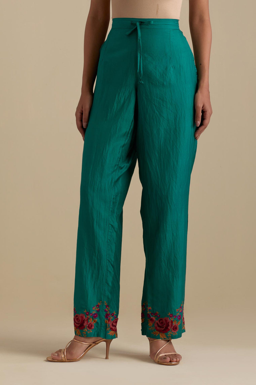 Persian green silk straight pants with roses in thread embroidery at the hem.