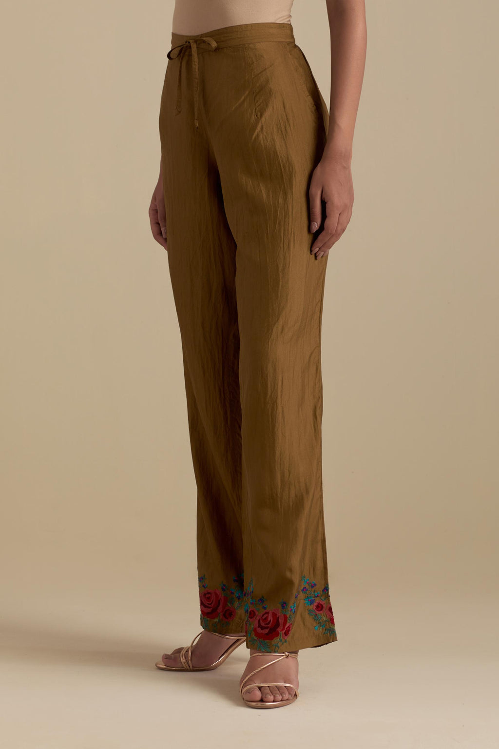 Olive silk straight pants with roses in thread embroidery at the hem.