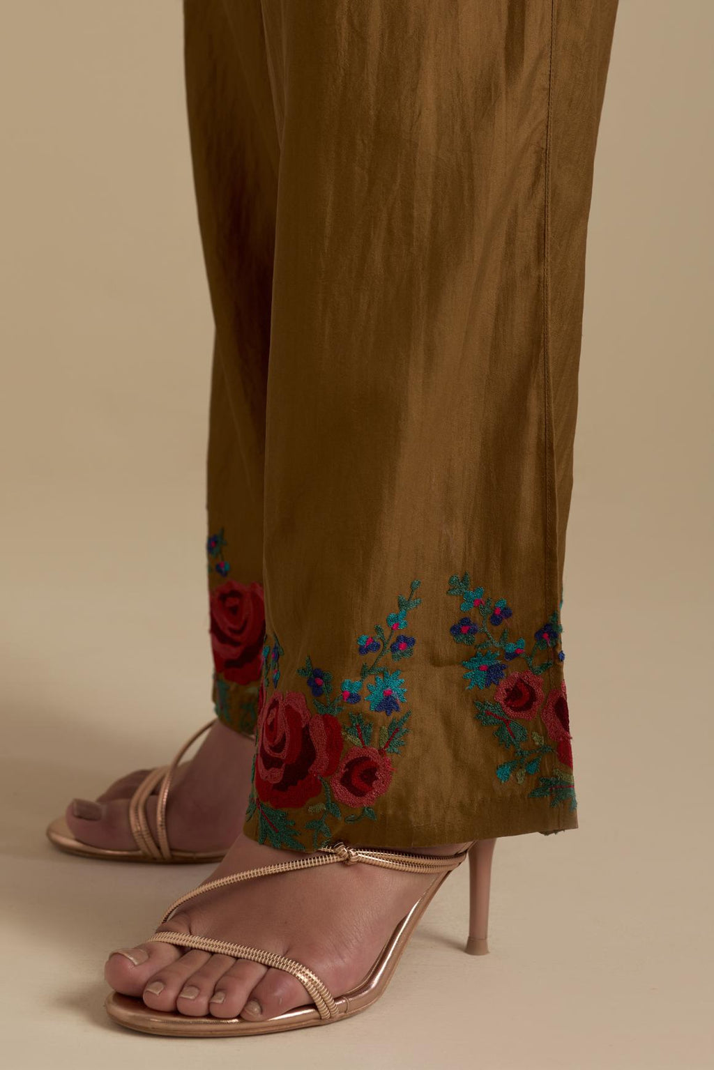 Olive silk straight pants with roses in thread embroidery at the hem.