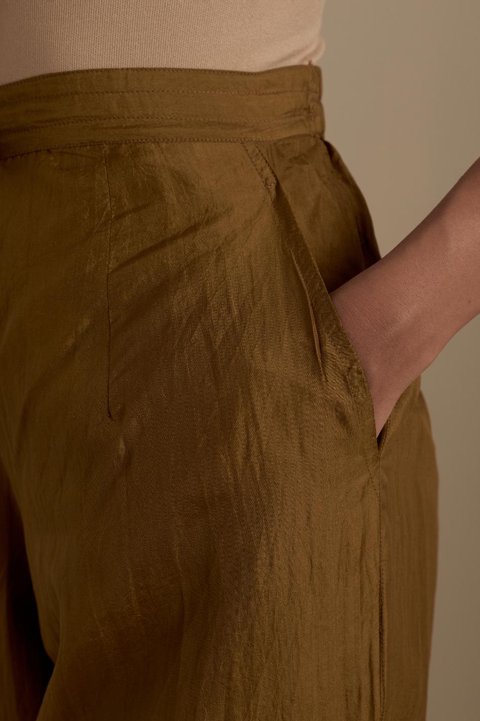 Olive silk straight pants with roses in thread embroidery at the hem.