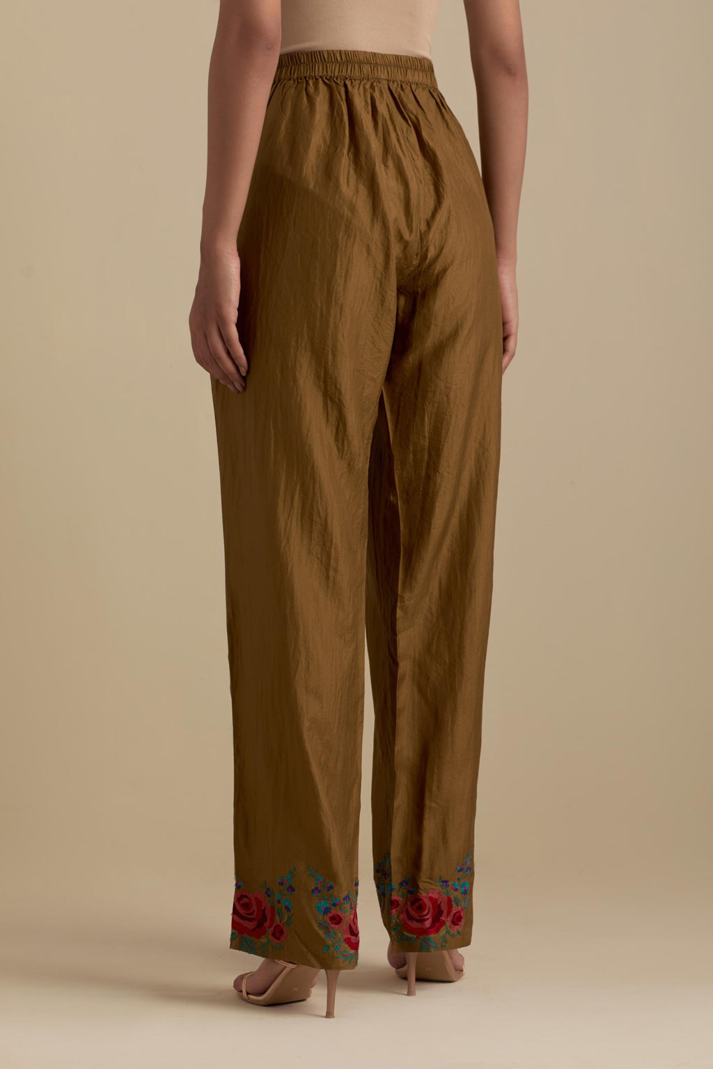 Olive silk straight pants with roses in thread embroidery at the hem.