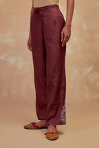 Deep berry silk straight pants with all-over hand block print, highlighted with embroidered boota at hem.
