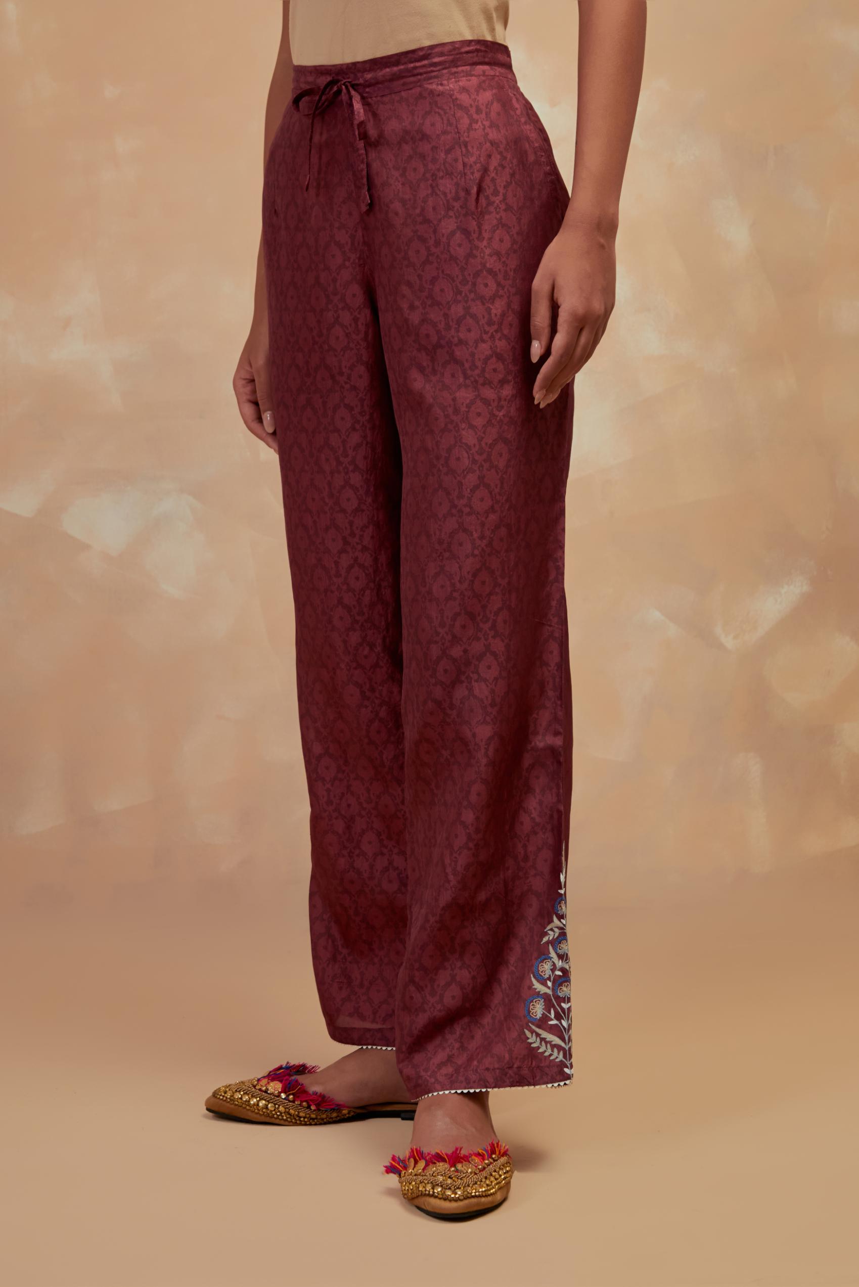 Deep berry silk straight pants with all-over hand block print, highlighted with embroidered boota at hem.