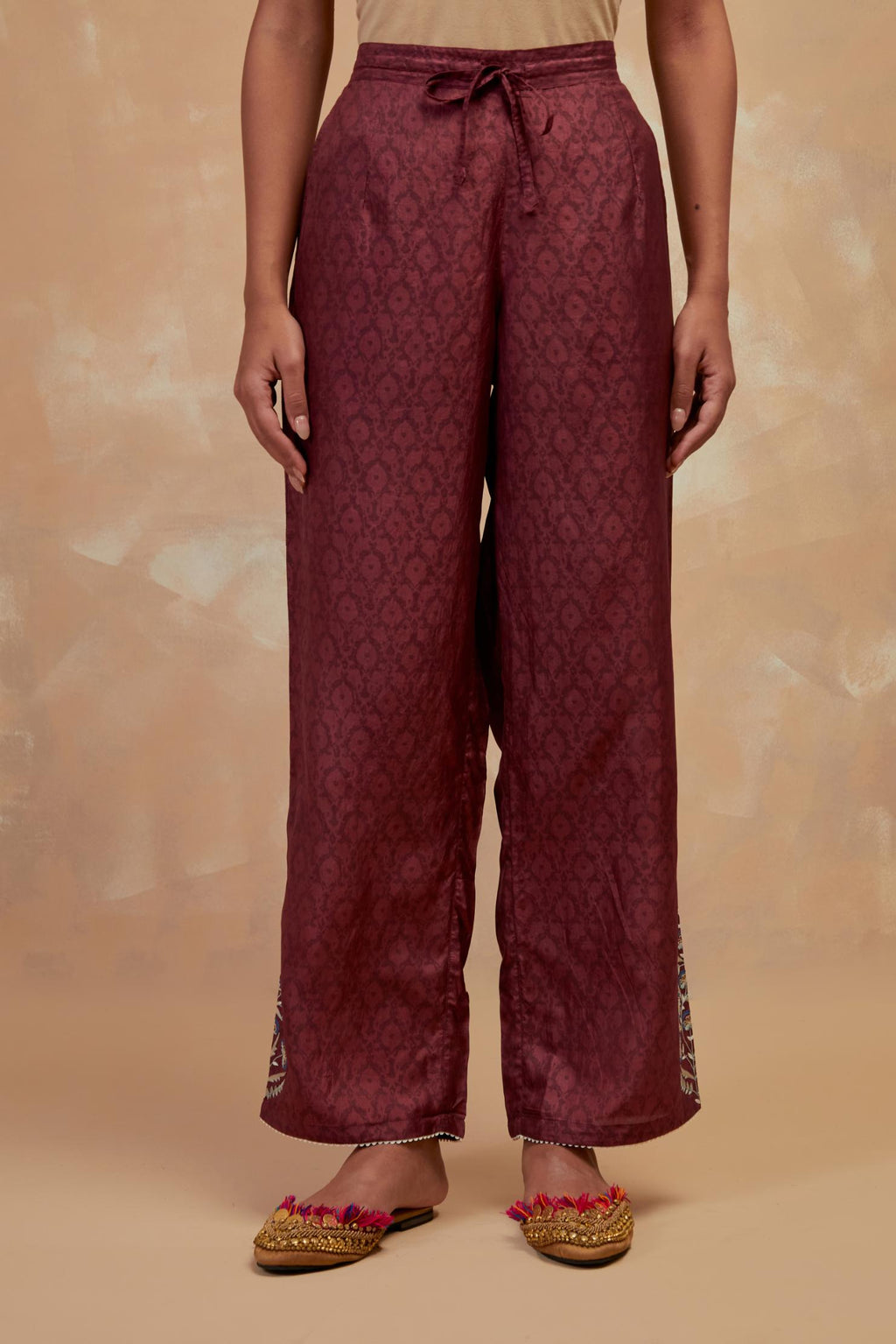 Deep berry silk straight pants with all-over hand block print, highlighted with embroidered boota at hem.