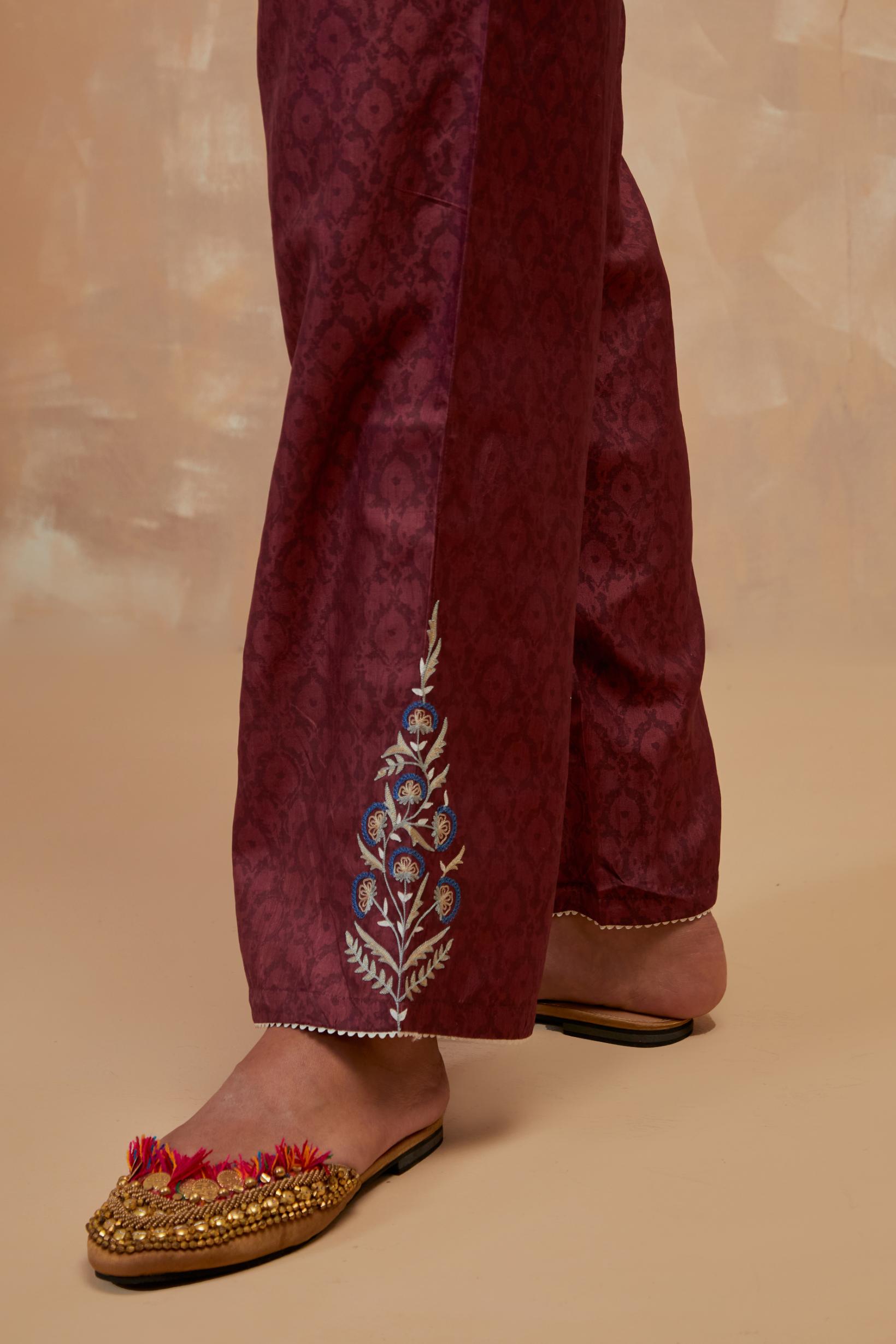 Deep berry silk straight pants with all-over hand block print, highlighted with embroidered boota at hem.