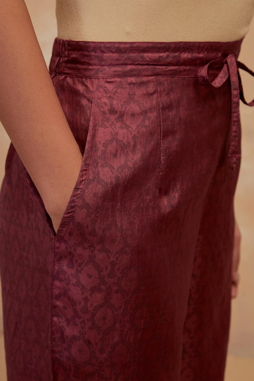 Deep berry silk straight pants with all-over hand block print, highlighted with embroidered boota at hem.