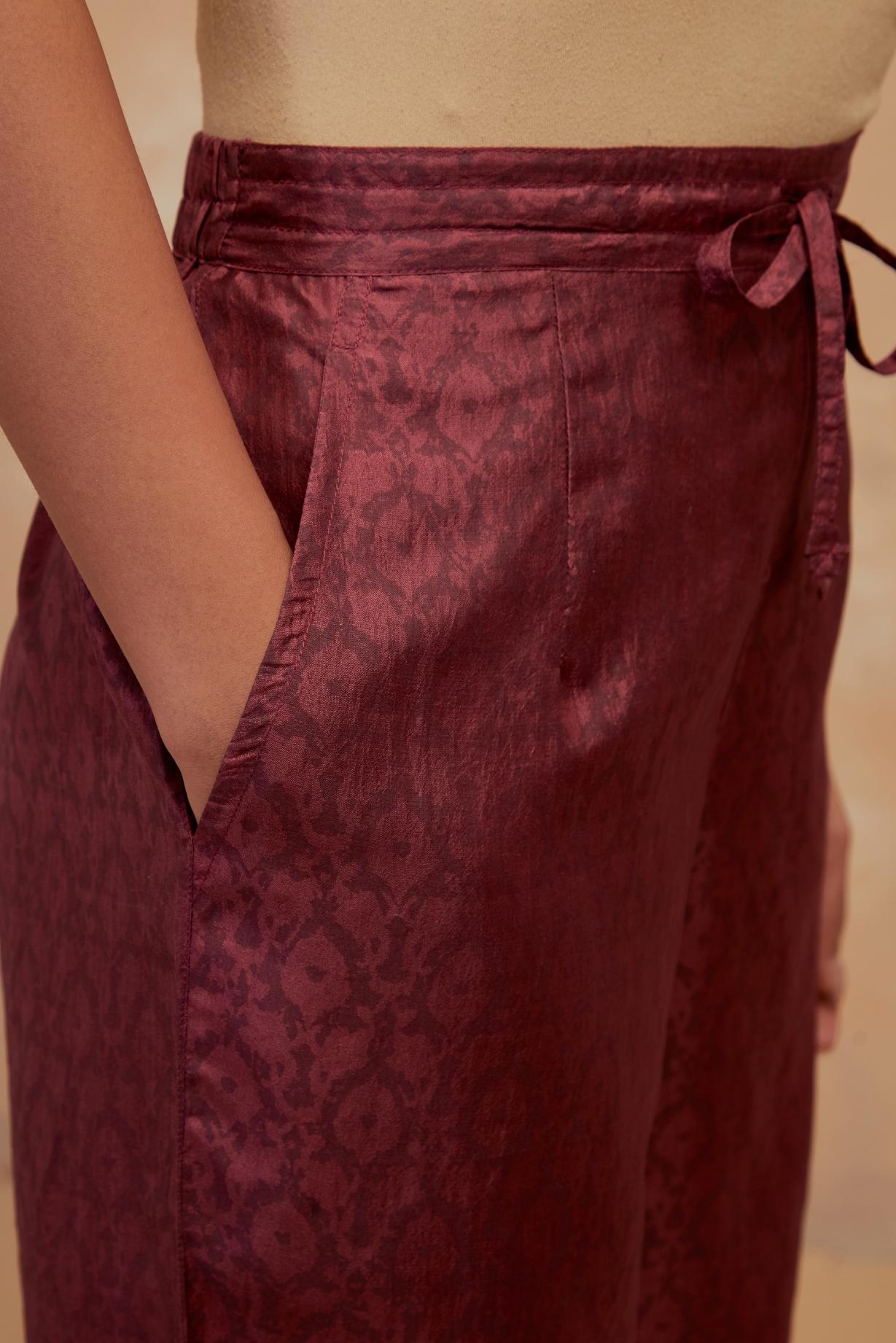 Deep berry silk straight pants with all-over hand block print, highlighted with embroidered boota at hem.