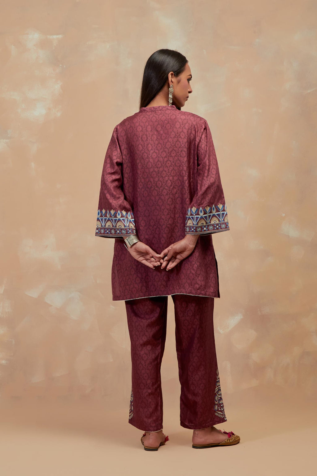 Deep berry silk hand block printed short top, highlighted with multi colored silk thread embroidery,  paired with Deep berry silk straight pants with all-over hand block print, highlighted with embroidered boota at hem.