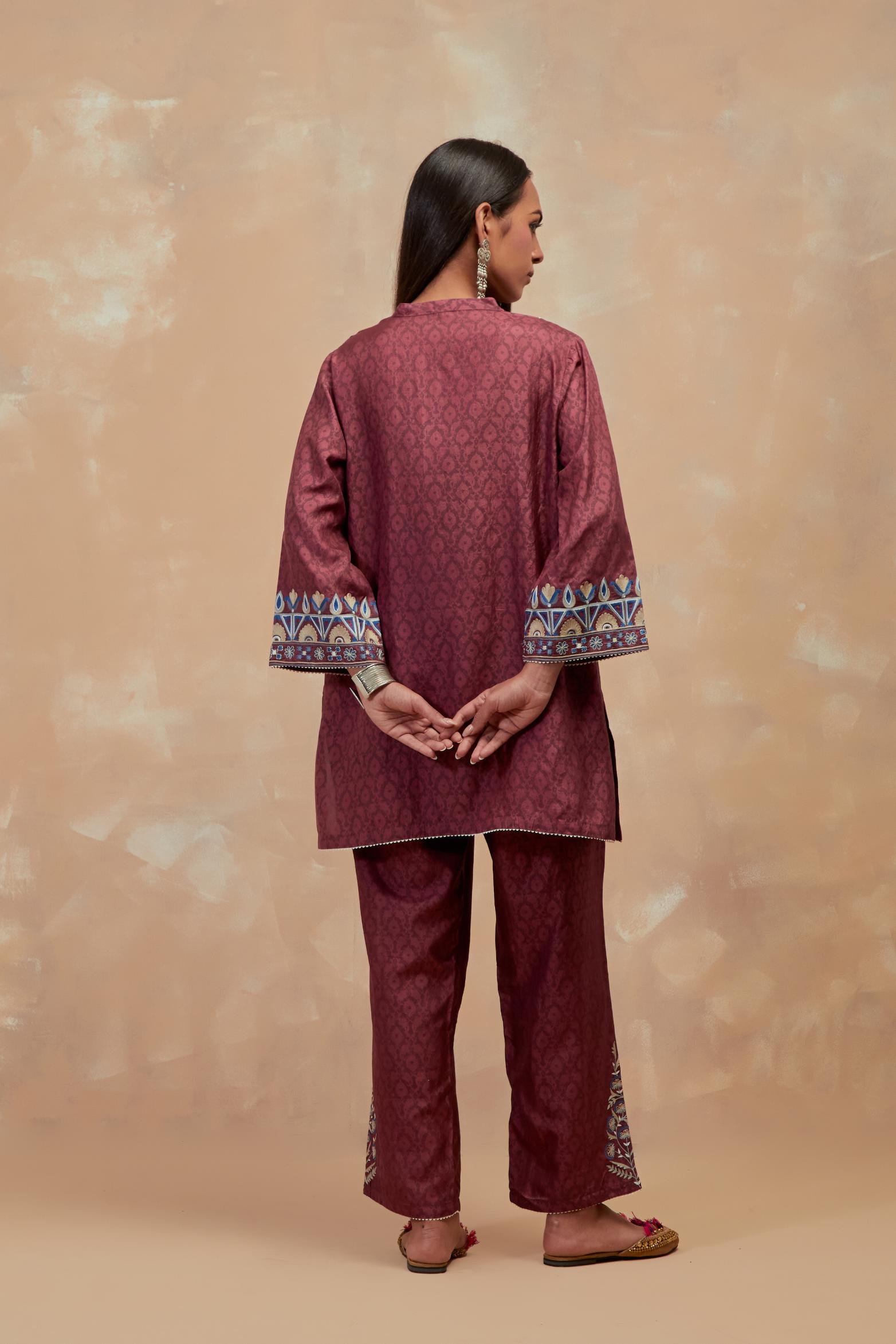 Deep berry silk hand block printed short top, highlighted with multi colored silk thread embroidery,  paired with Deep berry silk straight pants with all-over hand block print, highlighted with embroidered boota at hem.