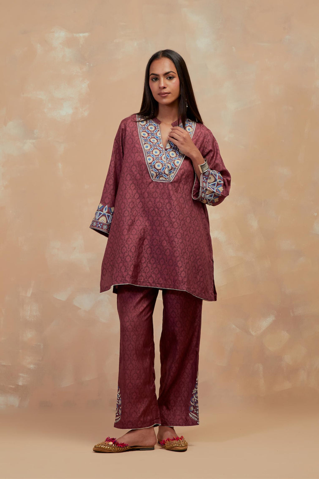 Deep berry silk hand block printed short top, highlighted with multi colored silk thread embroidery,  paired with Deep berry silk straight pants with all-over hand block print, highlighted with embroidered boota at hem.