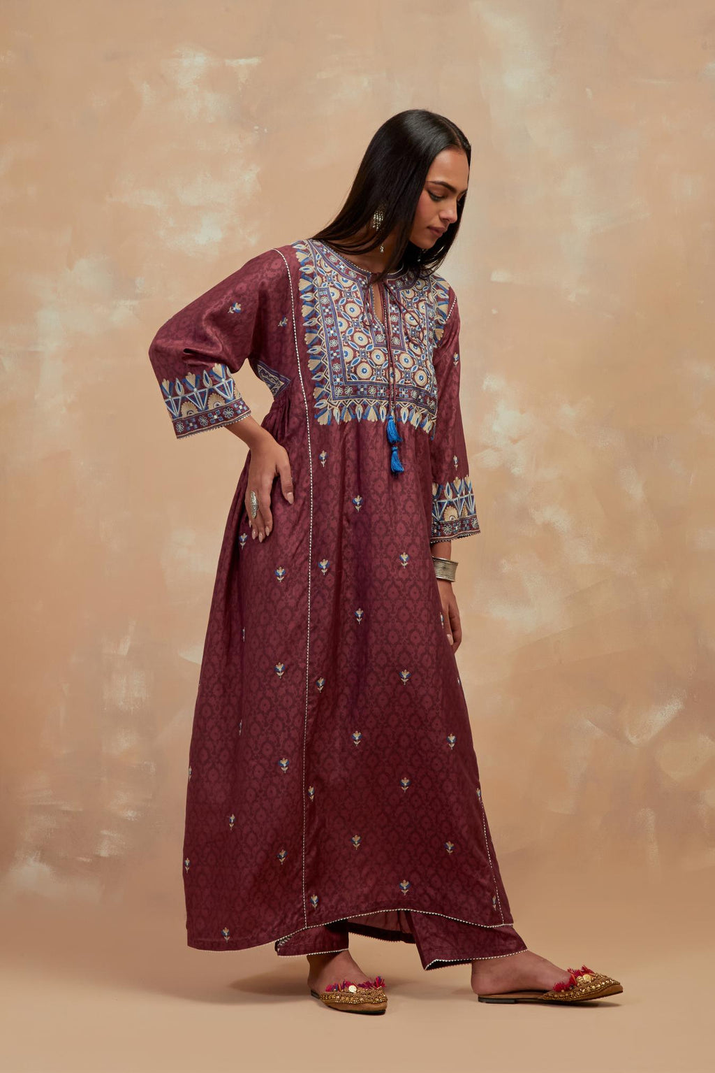 Deep berry silk hand block printed A-line long kurta set with all-over multi colored thread embroidery.