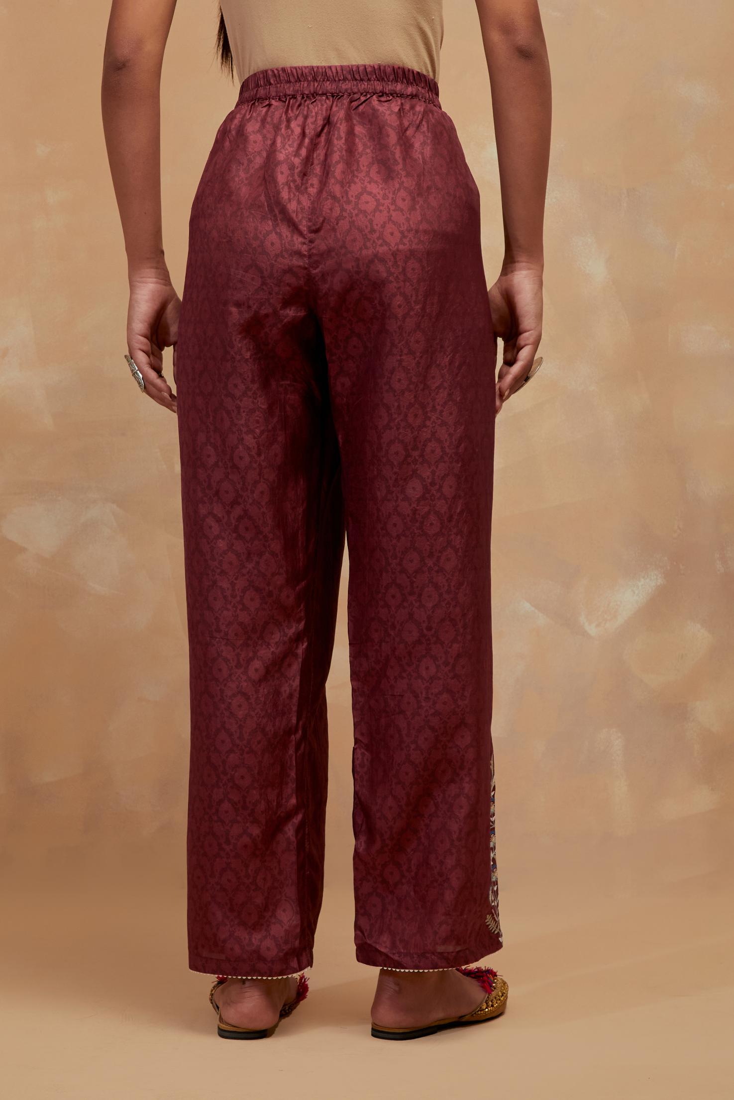 Deep berry silk straight pants with all-over hand block print, highlighted with embroidered boota at hem.