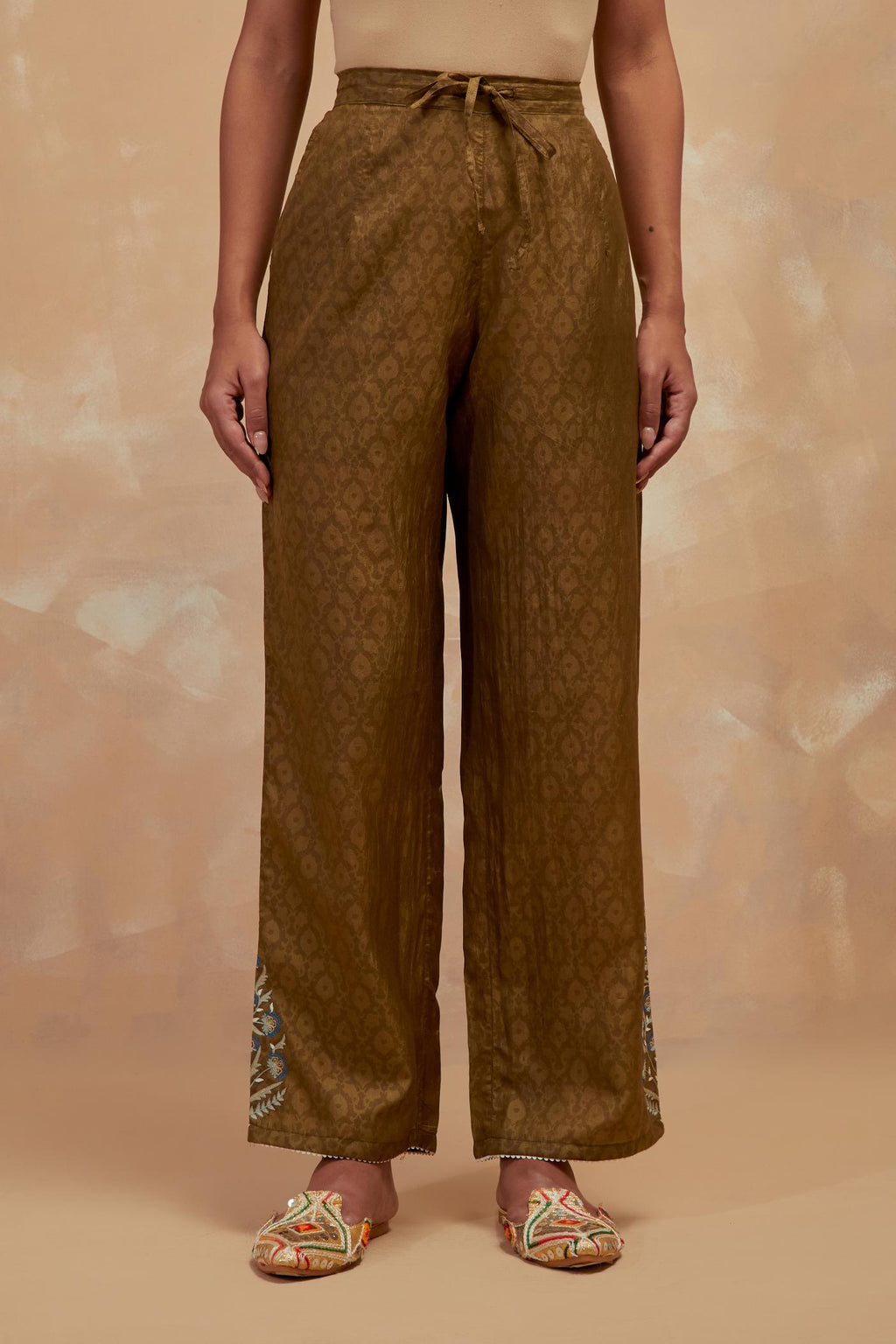 Olive green silk straight pants with all-over hand block print, highlighted with embroidered boota at hem.