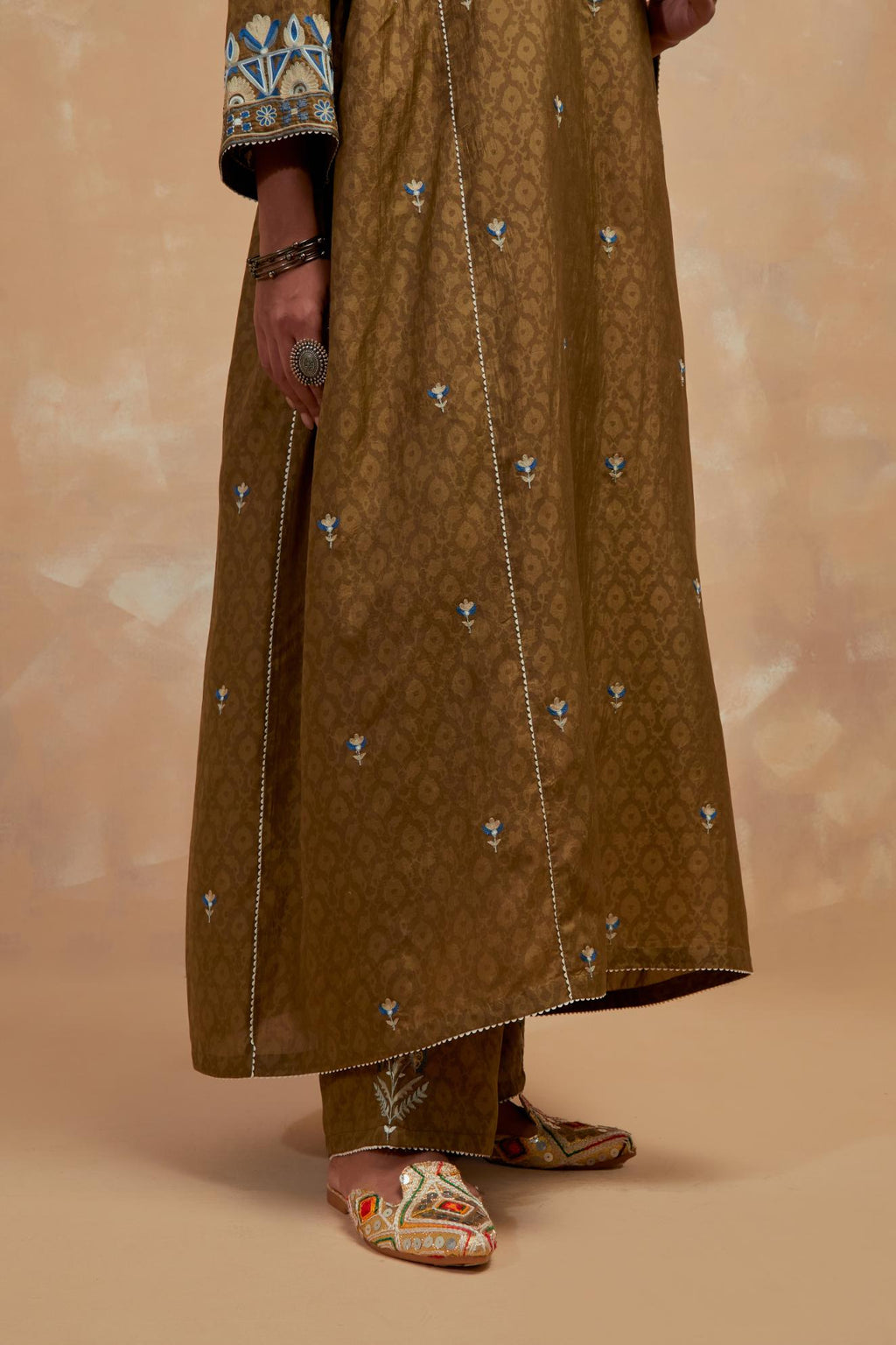 Olive green silk hand block printed A-line long kurta set with all-over multi colored thread embroidery.