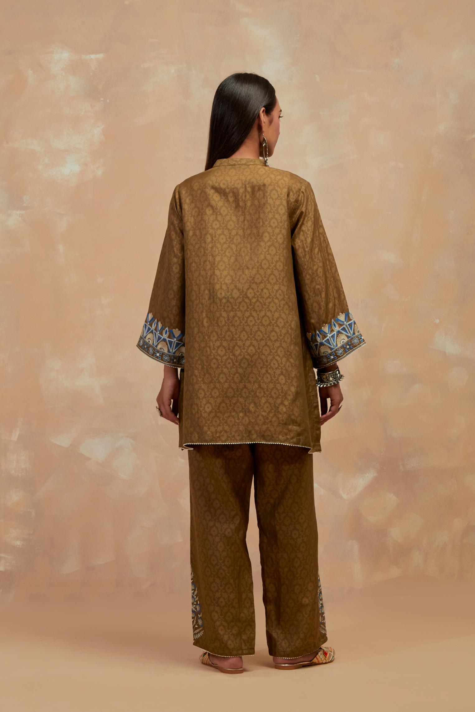Olive green silk hand block printed short top, highlighted with multi colored silk thread embroidery,  paired with Olive green silk straight pants with all-over hand block print, highlighted with embroidered boota at hem.