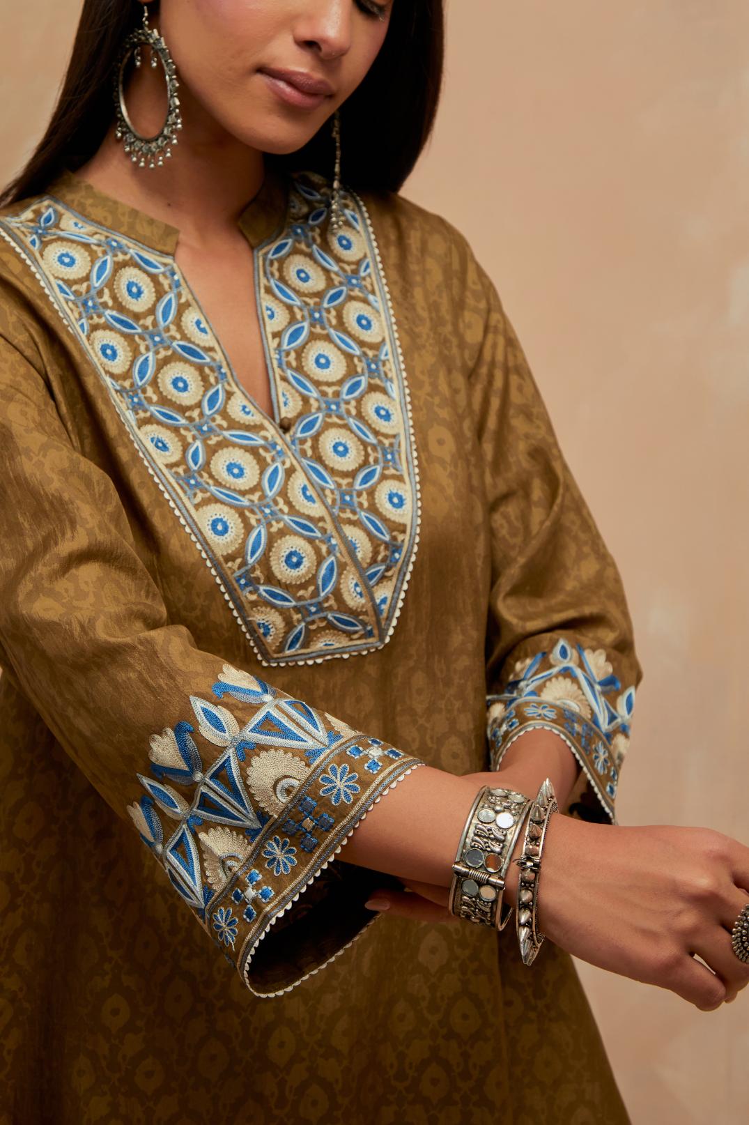 Olive green silk hand block printed short top, highlighted with multi colored silk thread embroidery,  paired with Olive green silk straight pants with all-over hand block print, highlighted with embroidered boota at hem.