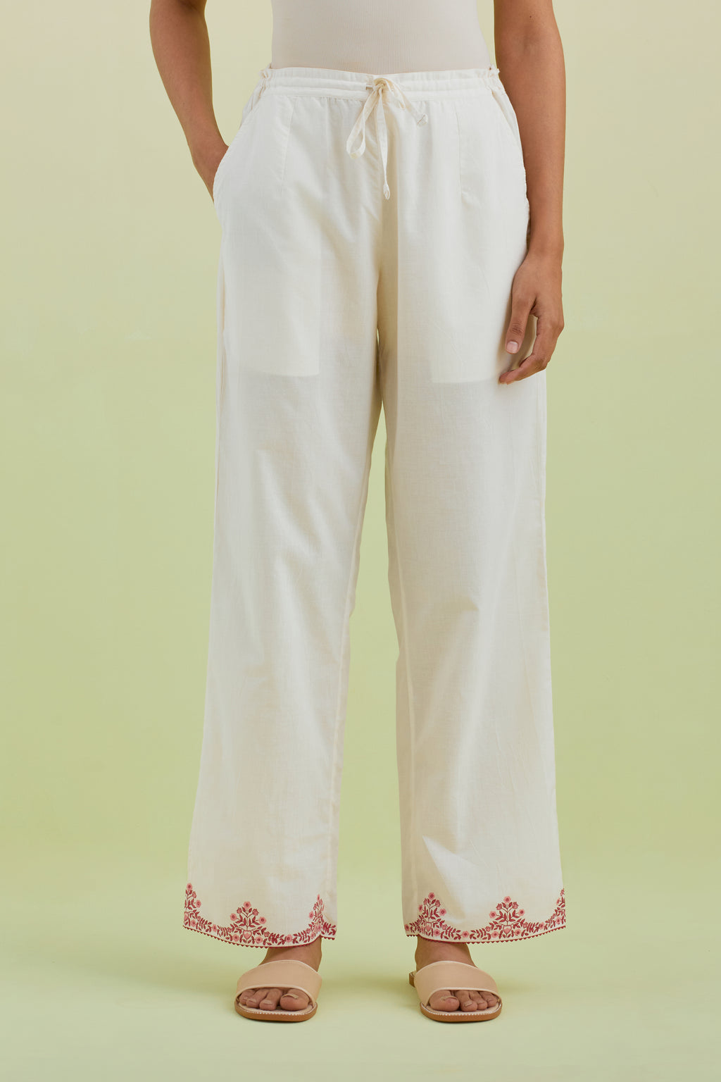 Off white straight pants with pink colored hand-block printed border at hem.