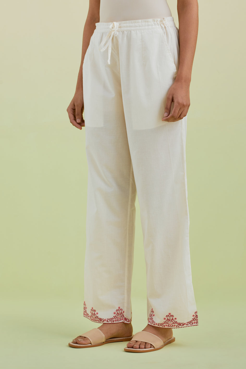 Off white straight pants with pink colored hand-block printed border at hem.