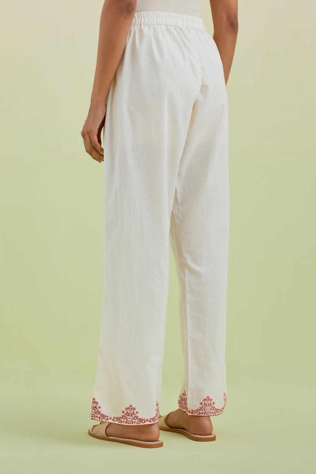 Off white straight pants with pink colored hand-block printed border at hem.